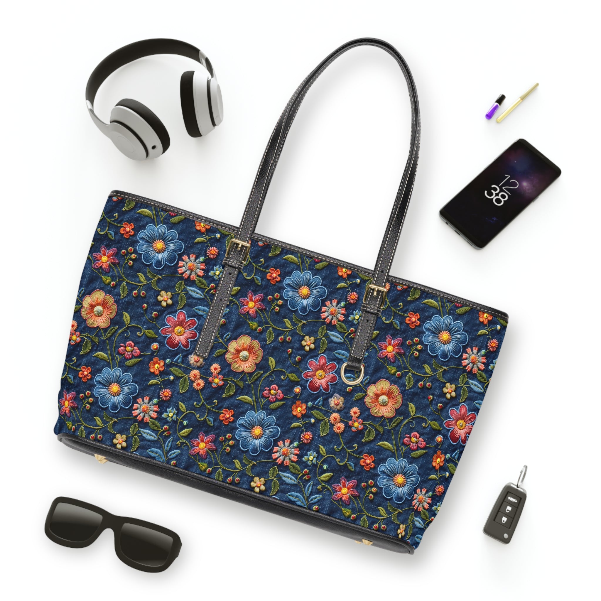 Floral-patterned handbag with accessories on a white background
