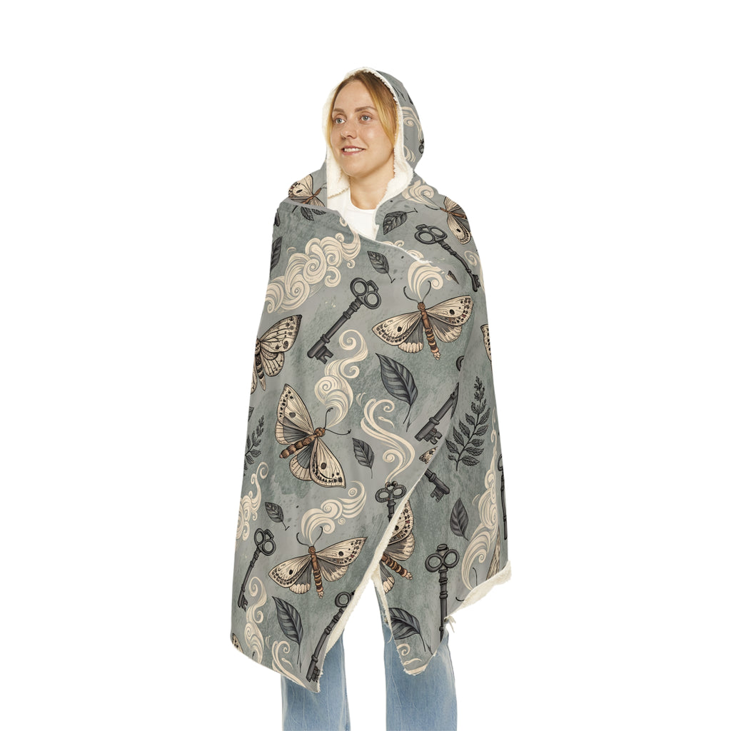 Hooded blanket with moth and key pattern on a white background