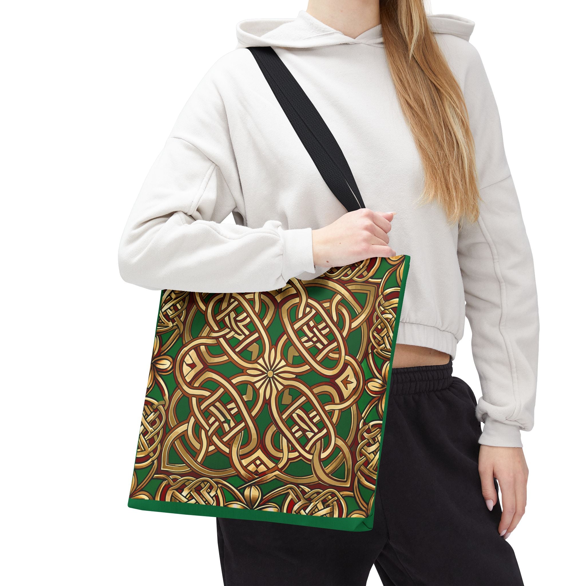 Person wearing a white hoodie with a green and gold patterned bag over their shoulder on a white background