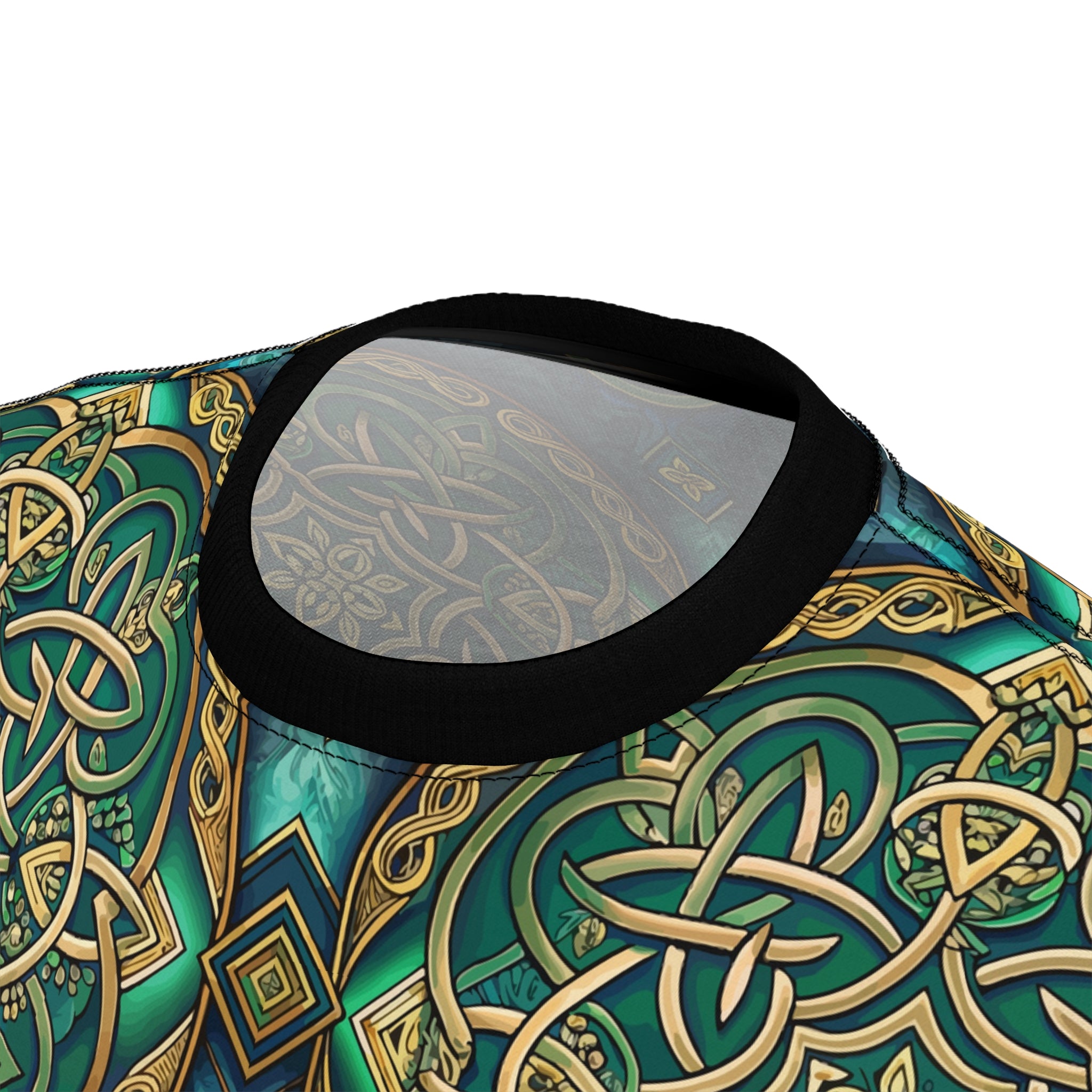 Close-up of a patterned fabric with Celtic knot designs in green and gold on a white background.