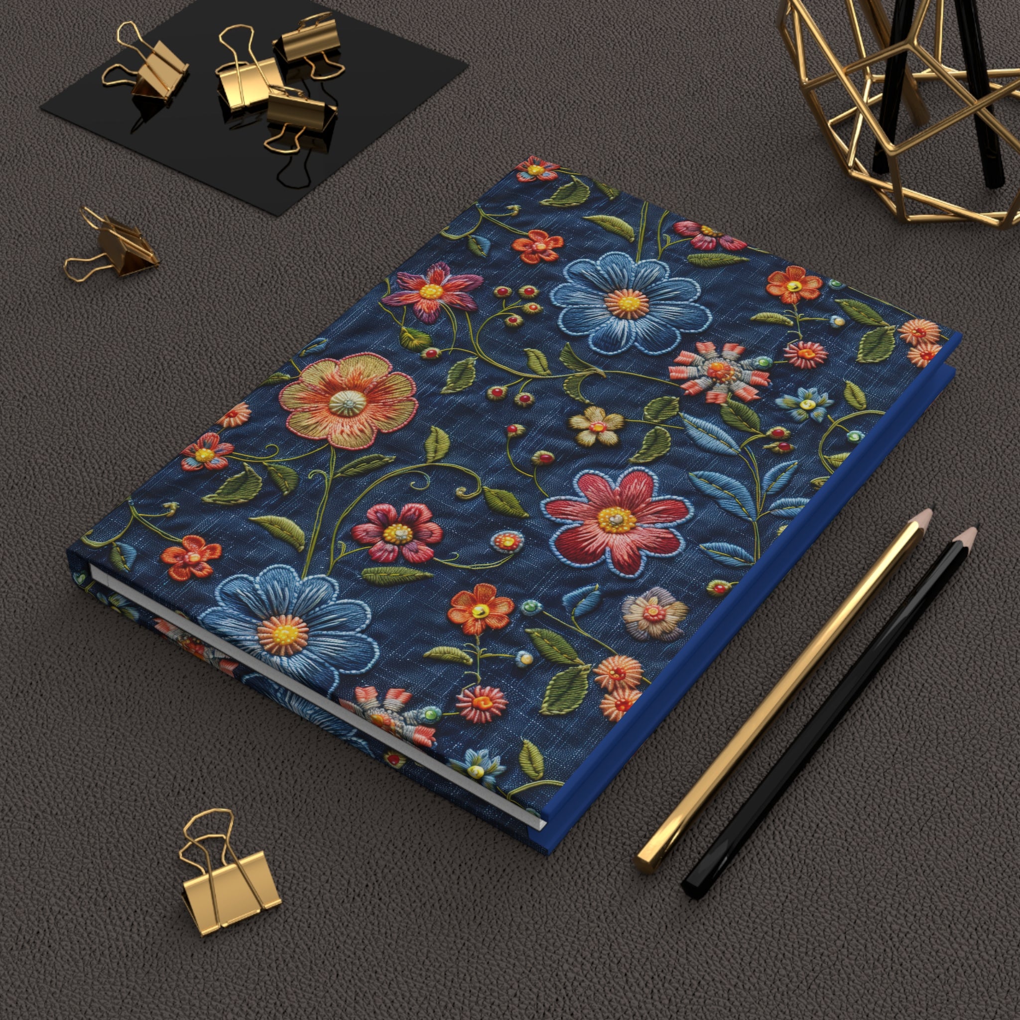 Floral notebook on a dark surface with office supplies