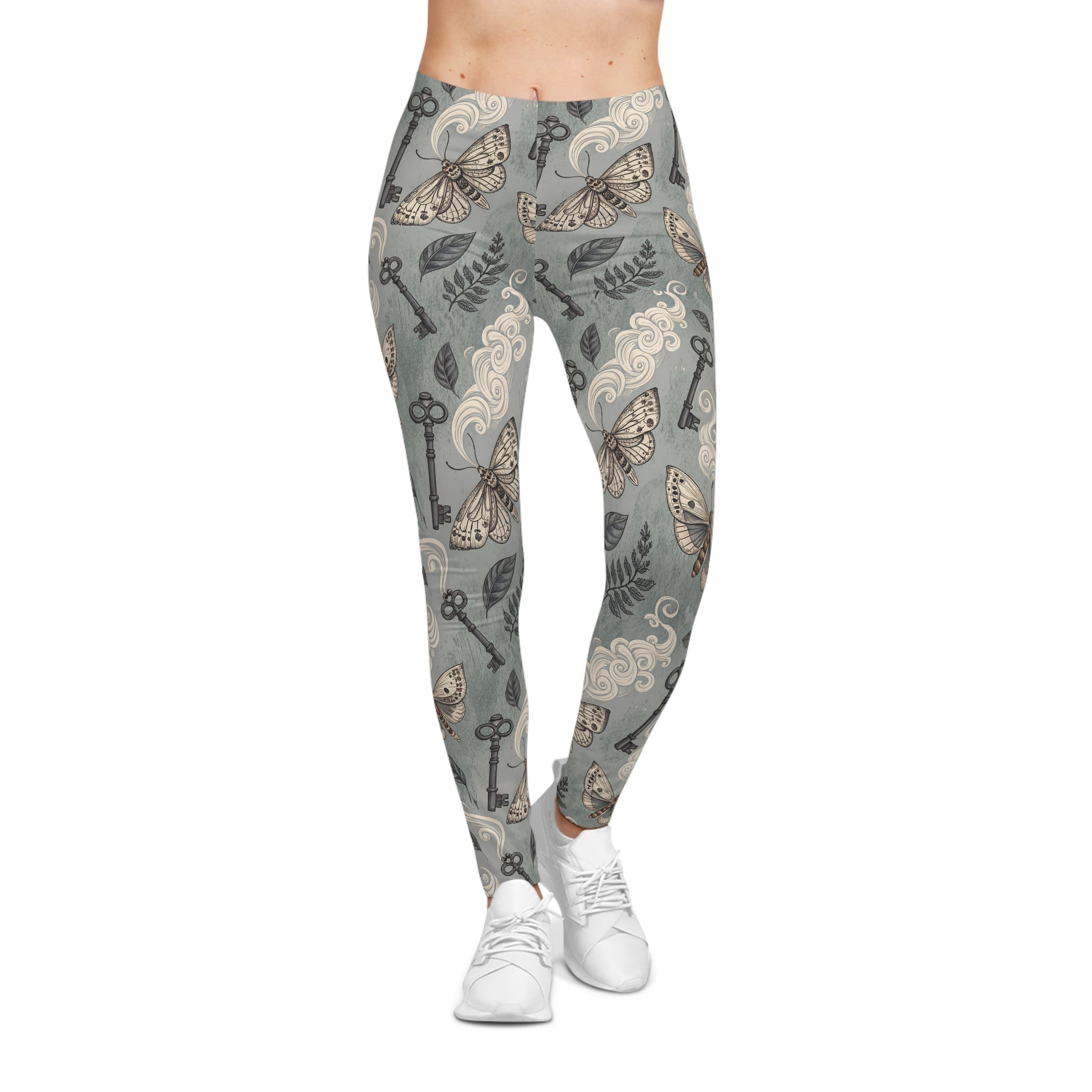 Leggings with a pattern of keys, moths, and leaves on a gray background.