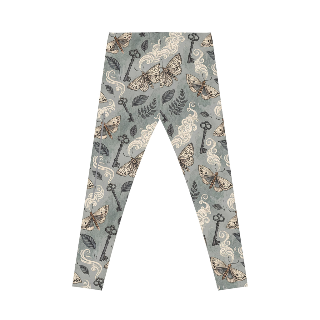 Leggings with a pattern of keys, moths, and leaves on a light grey background