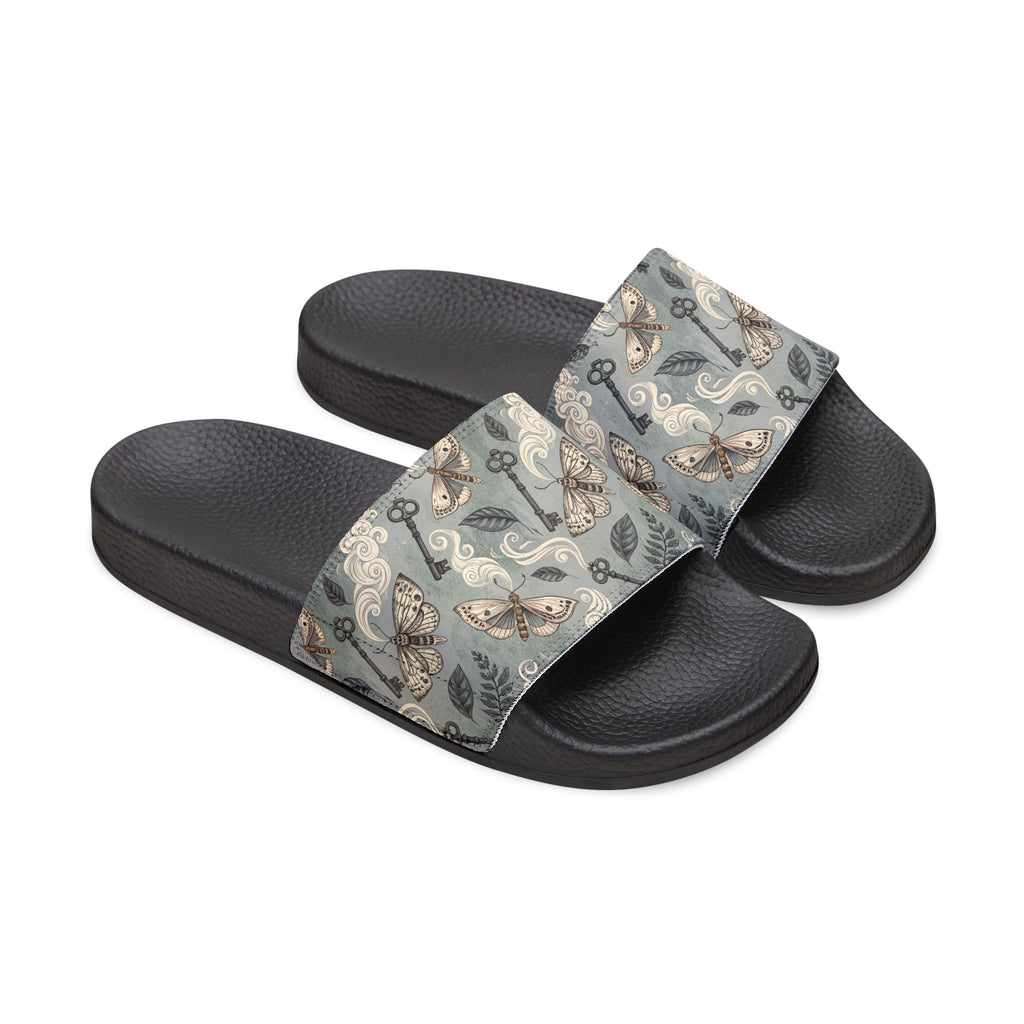 Black slide sandals with floral patterned straps on a white background