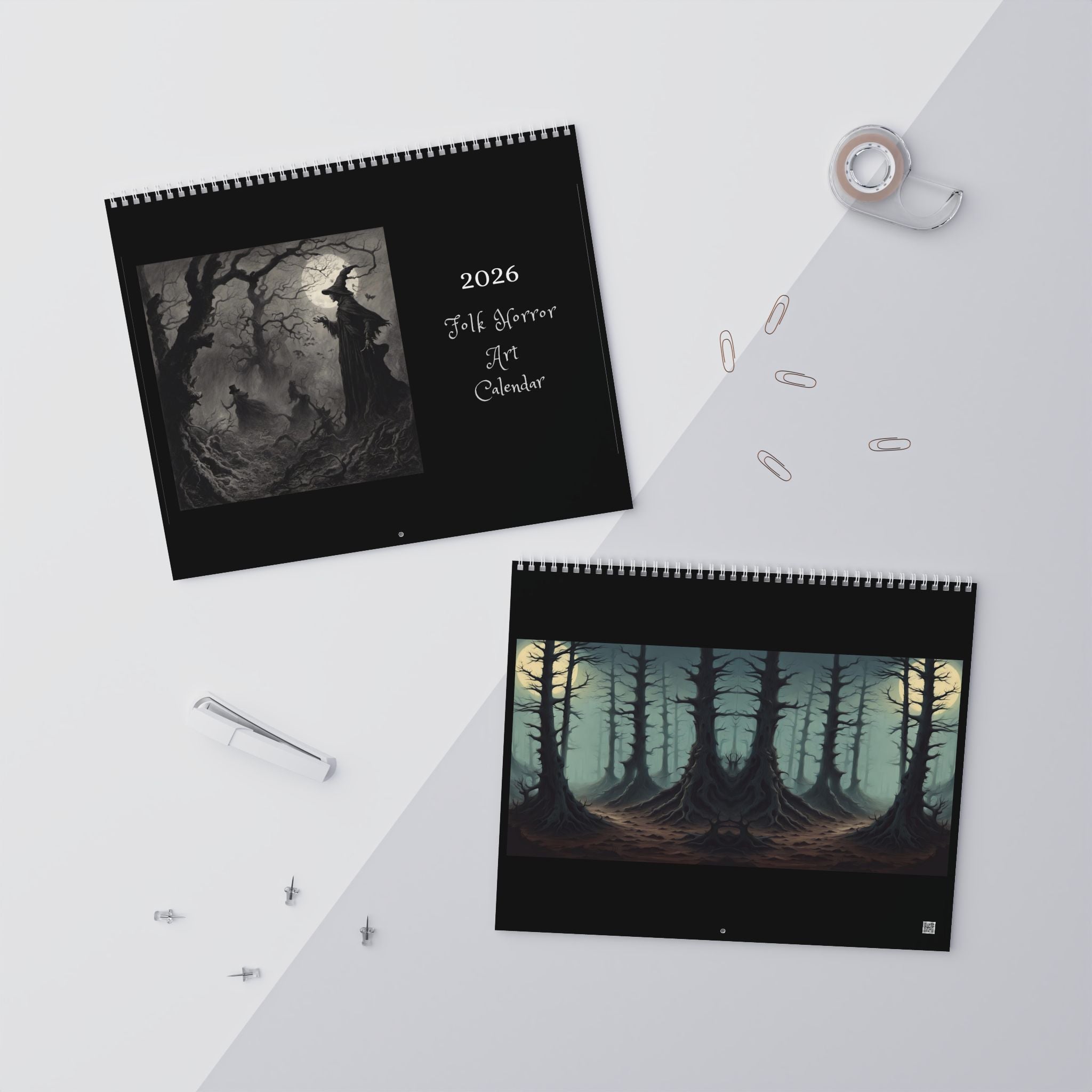 Two spiral-bound calendars with forest and moon designs on a white surface.