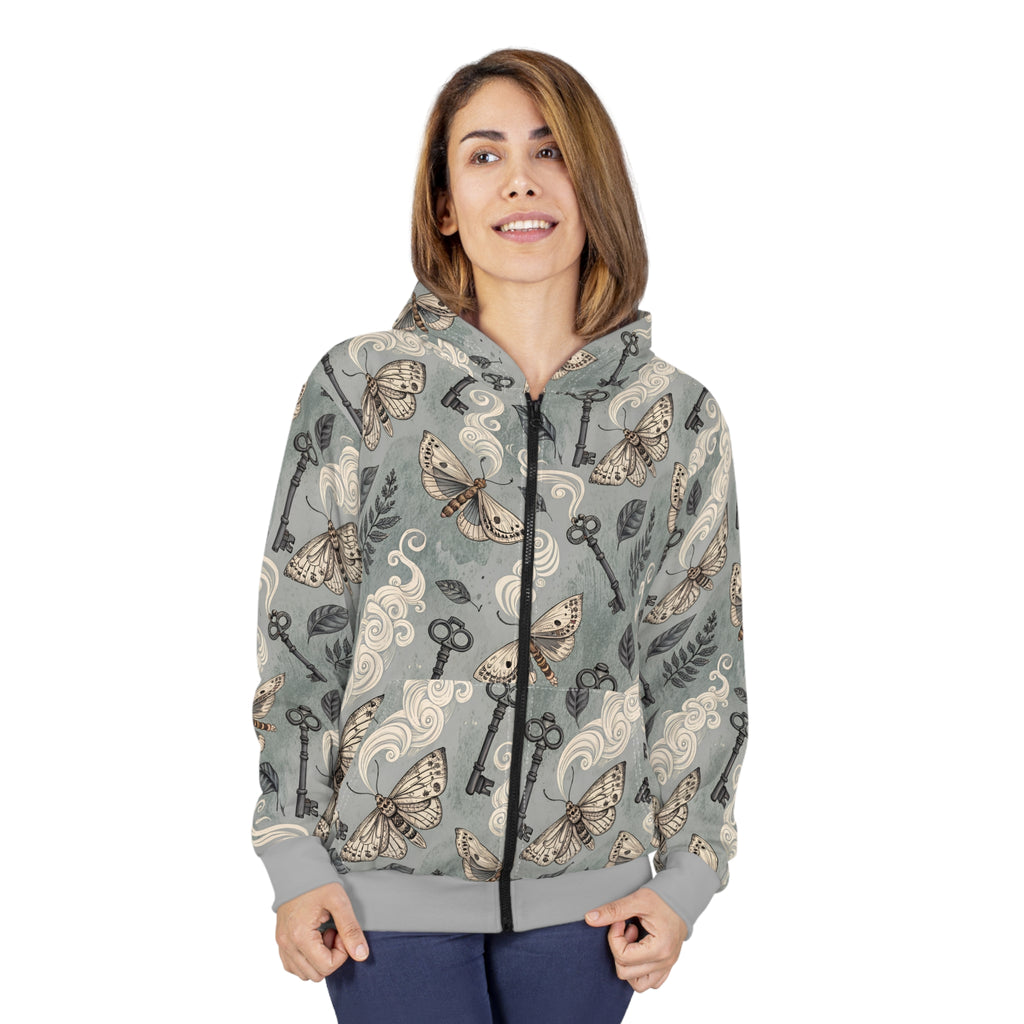 Woman wearing a patterned hoodie with keys and moths on a white background