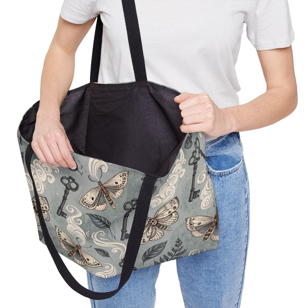 Person holding a tote bag  open with moth and key pattern