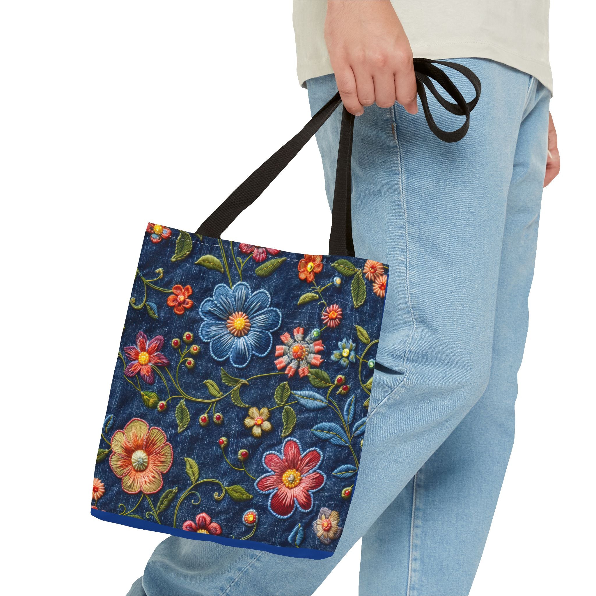 Person holding a floral embroidered bag with blue background