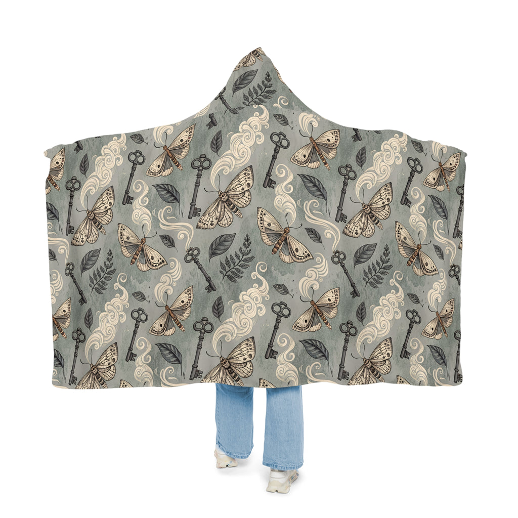 Hooded blanket with moth and key pattern on a white background