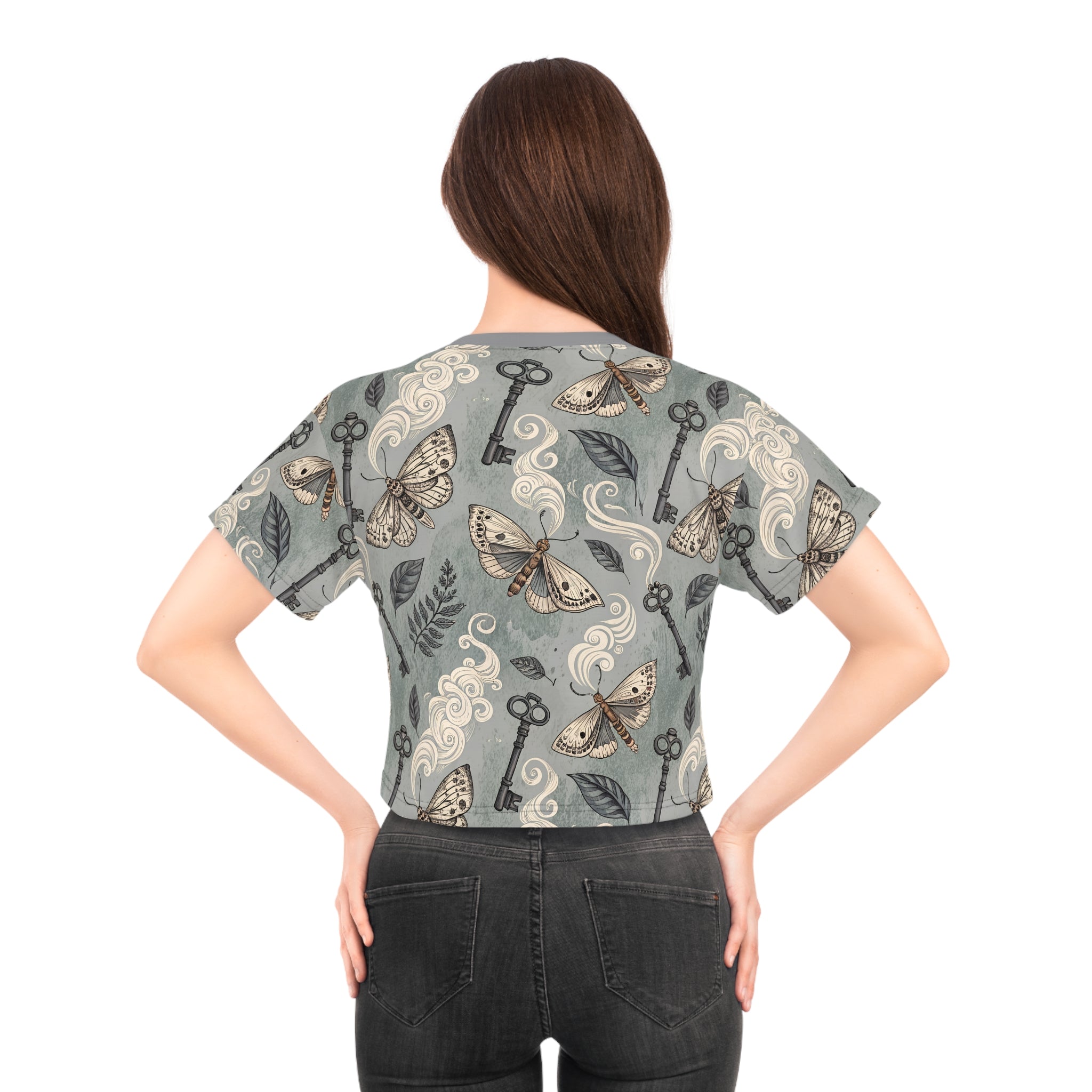 Woman wearing a patterned shirt with keys and moths on a white background