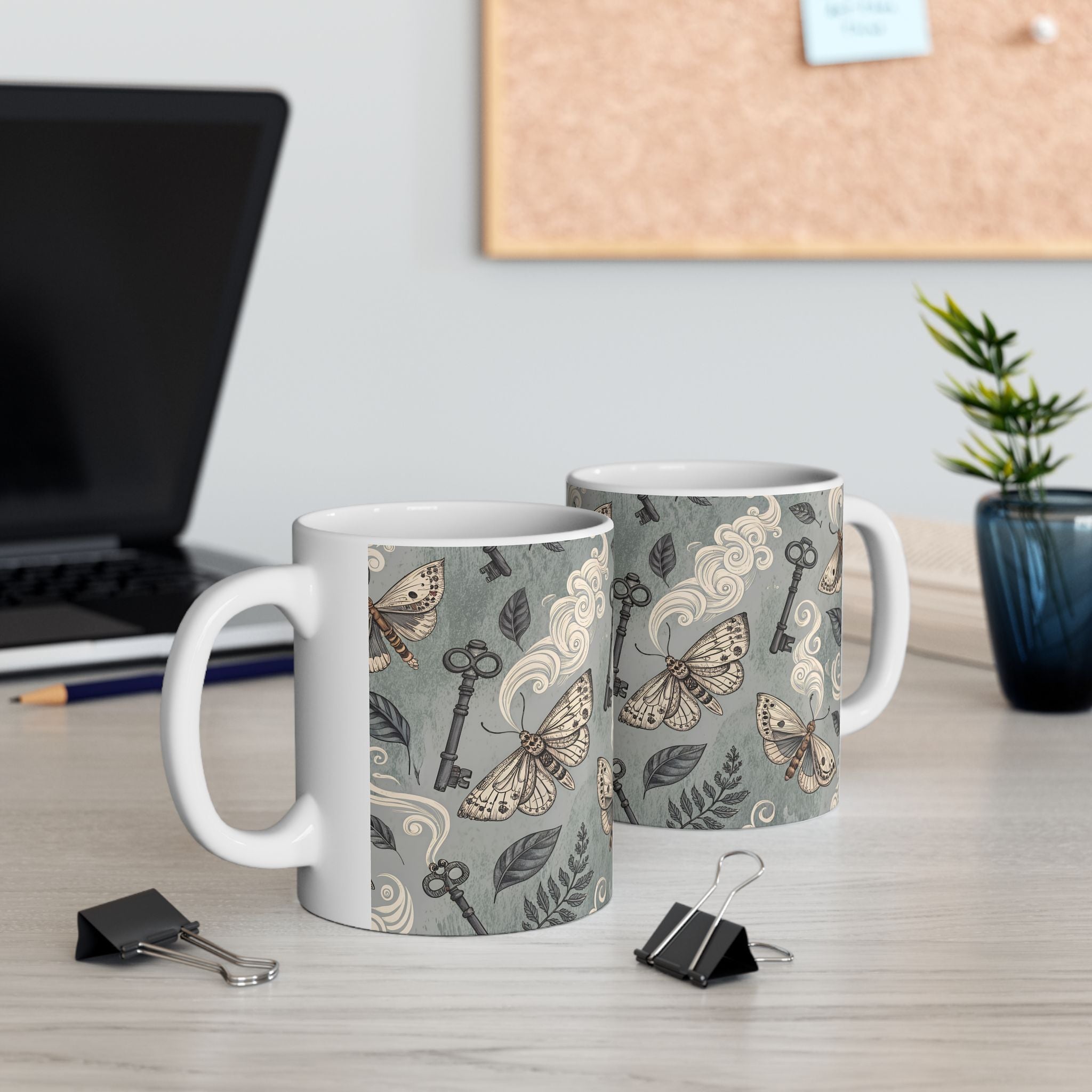 Two mugs with decorative patterns on a desk with office supplies.