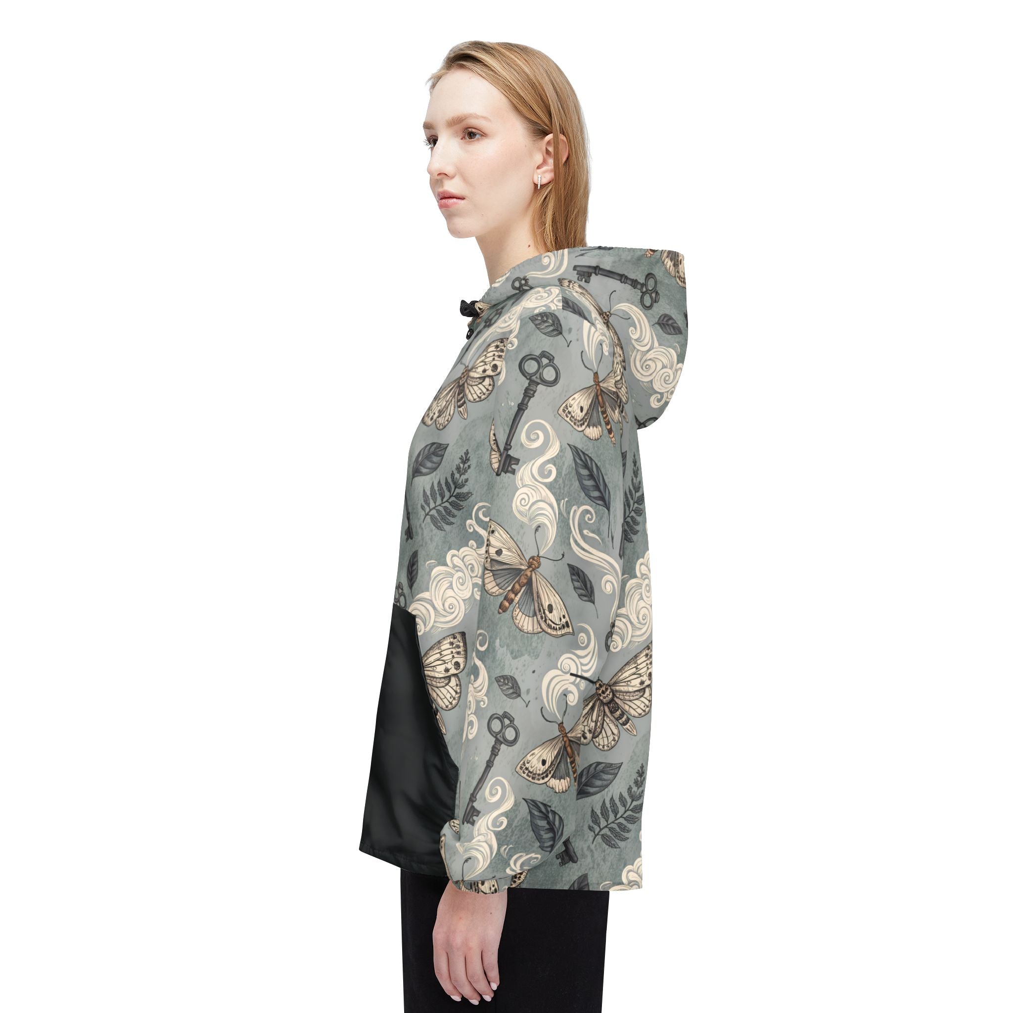 Woman wearing a gray hooded jacket with decorative patterns on a white background