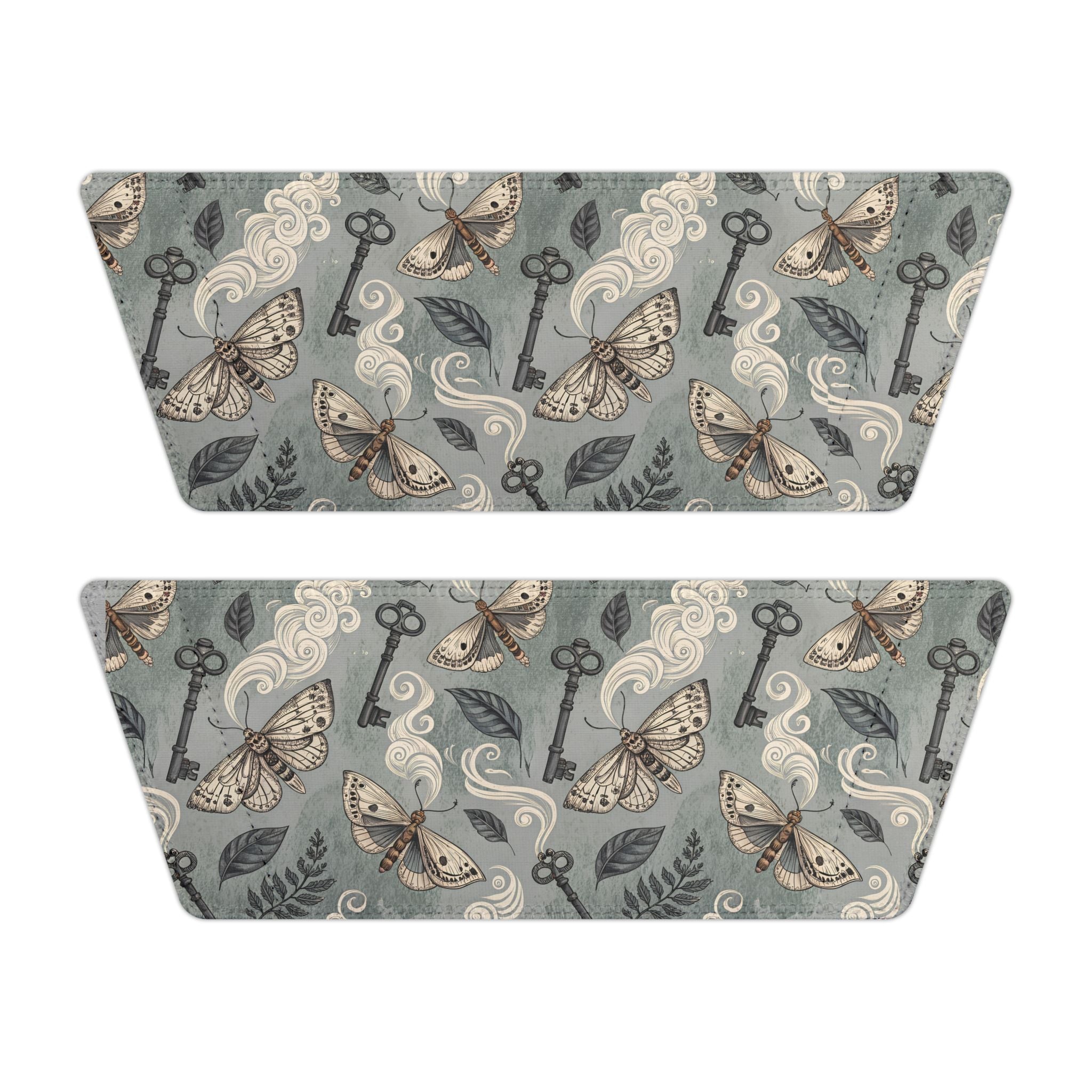 Two matching sandal tops with a decorative pattern of keys, moths, and leaves on a gray background.