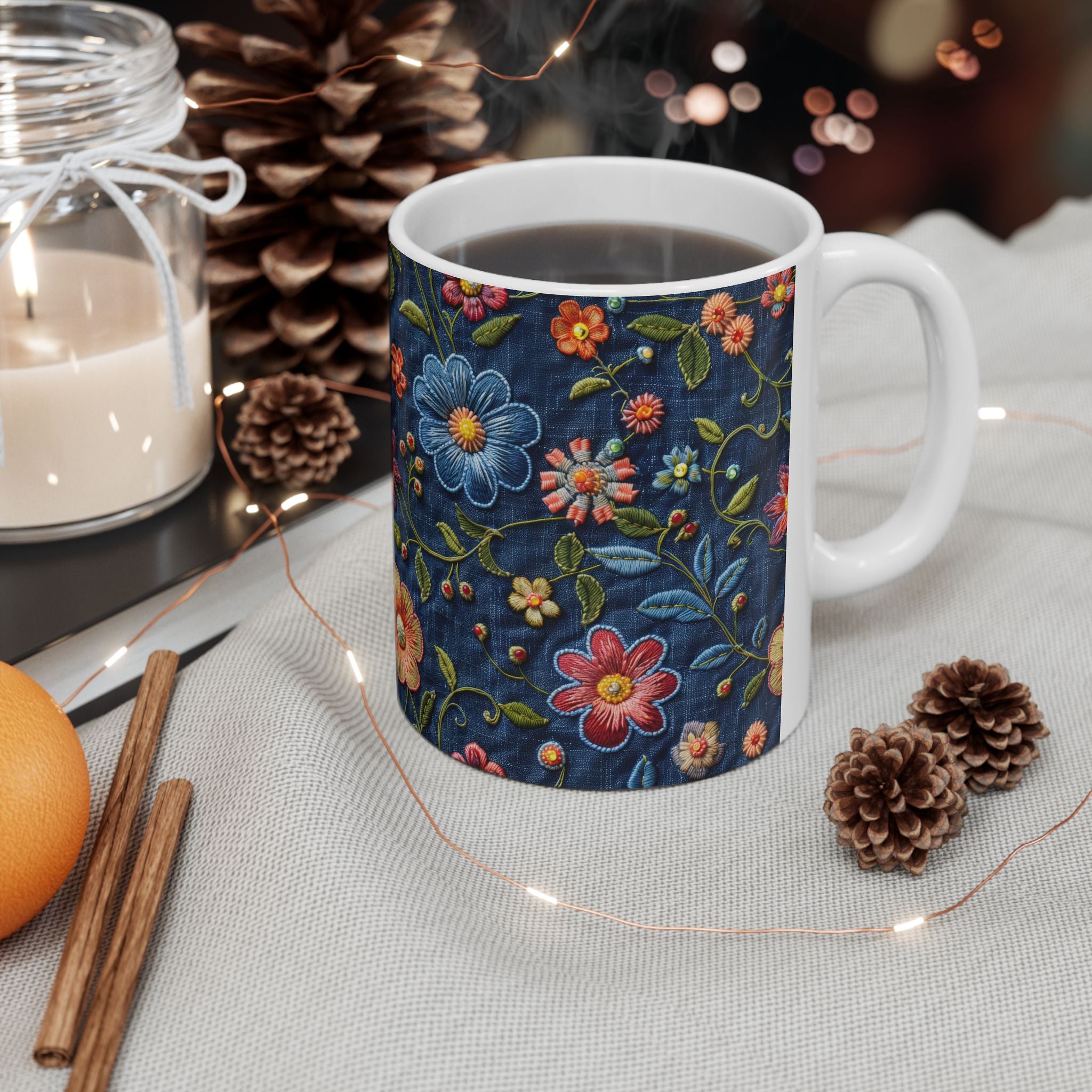 Mug with floral design on a table with candles and pinecones