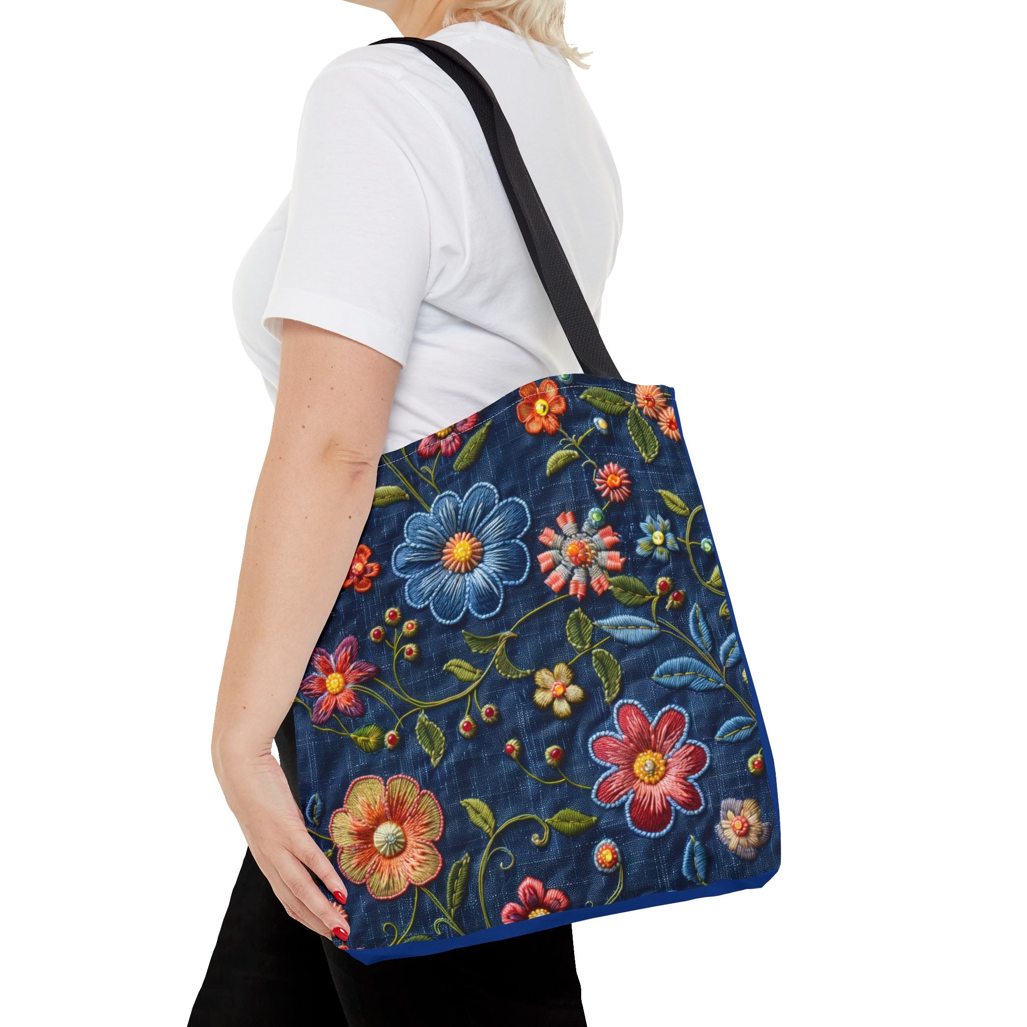 Person carrying a blue floral embroidered bag on a white background