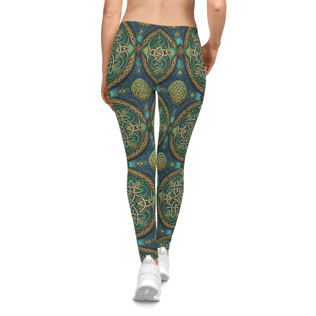 Person wearing Celtic gold and green patterned leggings on a white background
