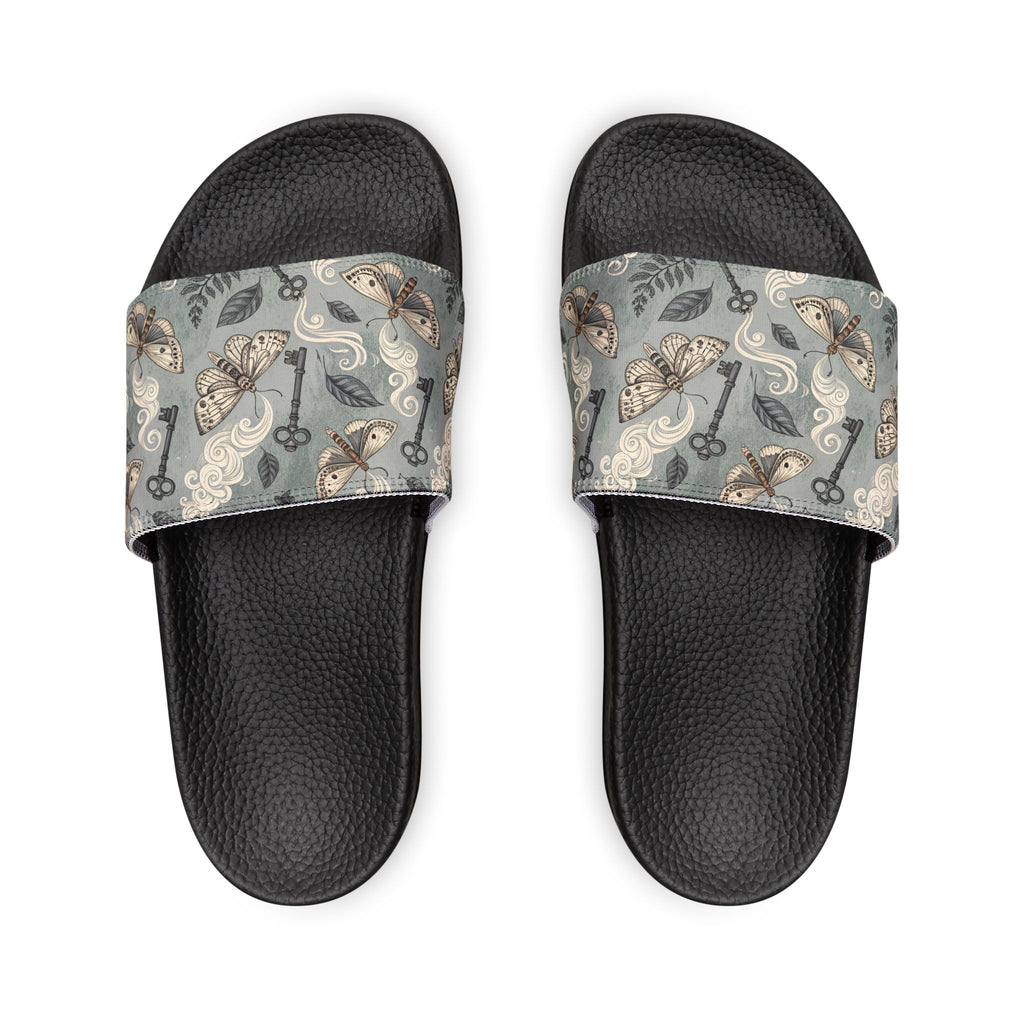 Black slides with patterned straps on a white background