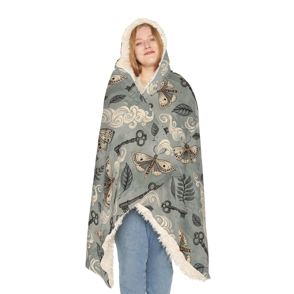 Hooded blanket with moth and key pattern on a white background