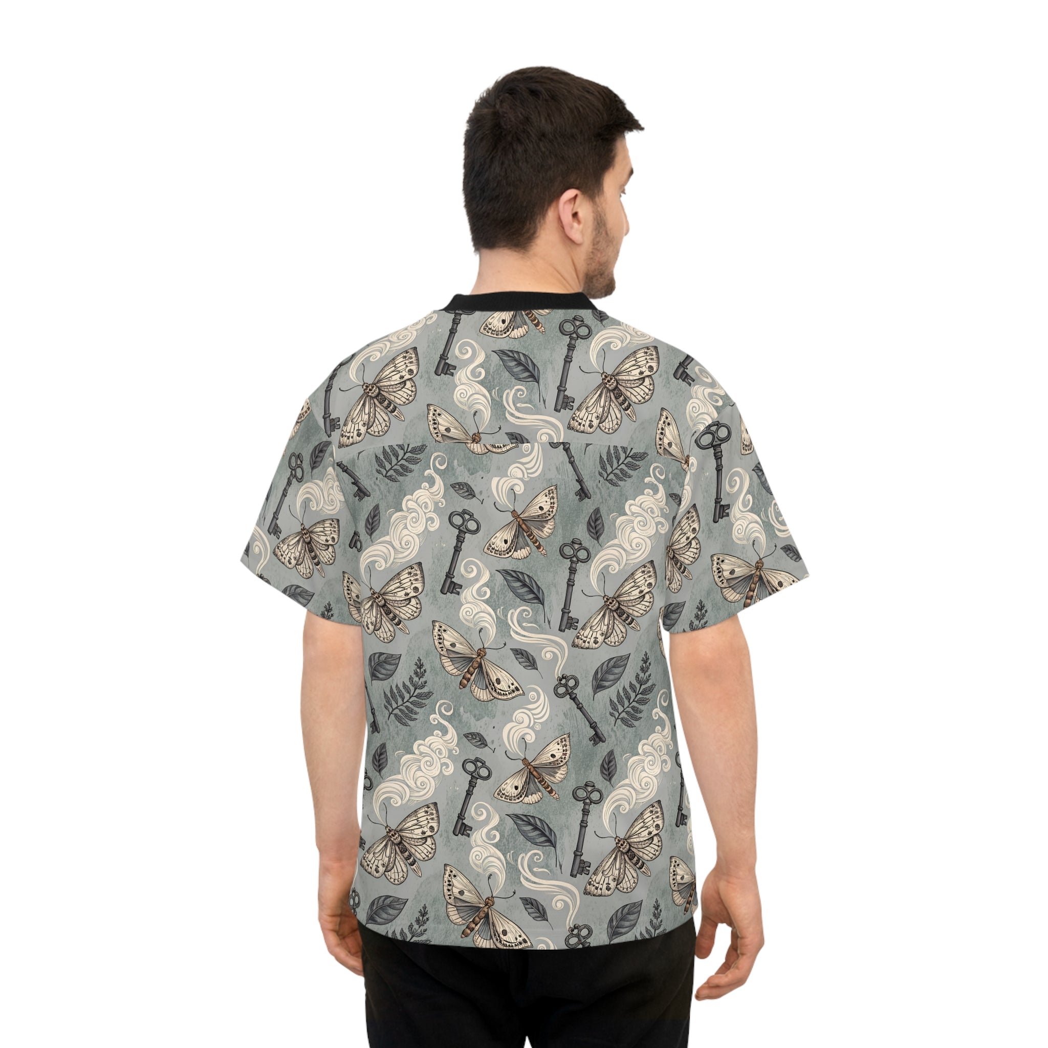 Man wearing a patterned shirt with keys and moths on a white background